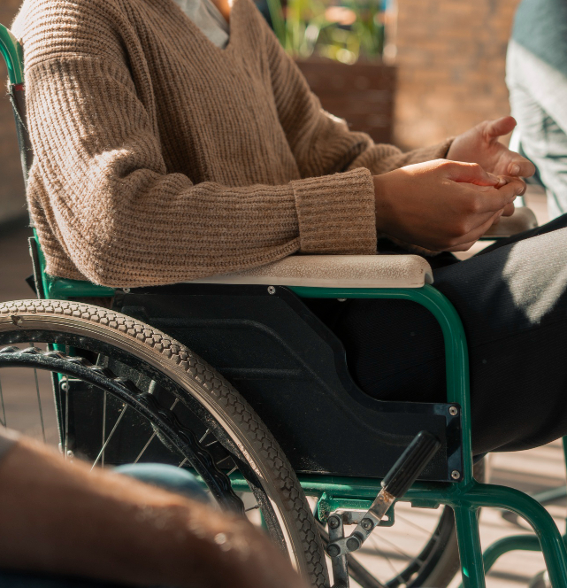 Persona en silla de ruedas atendida por una cuidadora